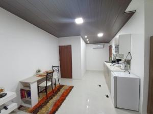 kuchnia z białymi ścianami, stołem i blatem w obiekcie Suite elegante en urbanización privada w mieście Machala