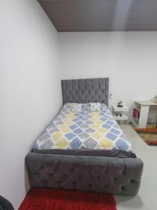 1 dormitorio con 1 cama con cabecero gris en Suite elegante en urbanización privada, en Machala