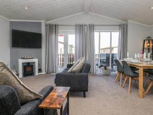 a living room with couches and a table and a dining room at Lakeside 20 in Carnforth
