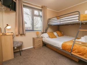 a bedroom with a bunk bed and a desk at Lakeside 20 in Carnforth
