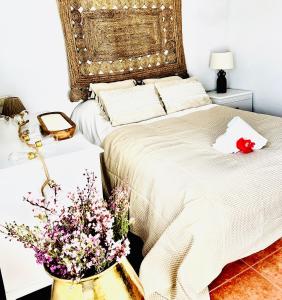 Un dormitorio con una cama con una flor. en EDEN GARDEN b&b, en Ponferrada