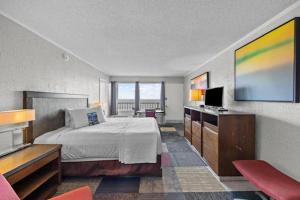 um quarto de hotel com uma cama e uma televisão de ecrã plano em The Red Tree Inn em Myrtle Beach