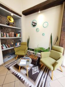 a living room with two chairs and a coffee table at Hotel Raymipampa in Cuenca