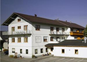 duży biały budynek z czarnym dachem w obiekcie Landgasthof & Seminarhotel Kobleder w mieście Mettmach
