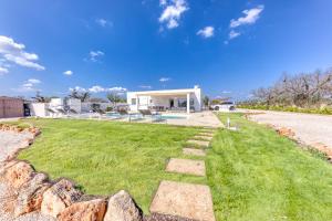 un patio con una pared de piedra y una casa en Villa Cento Ulivi, en Ugento