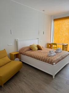 een slaapkamer met een bed en een bank bij Molo '93 - RoomsAndSea in Belvedere Marittimo