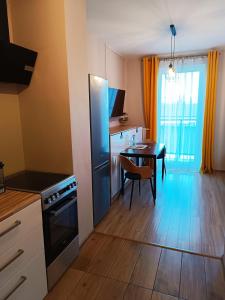 uma cozinha com uma mesa e um frigorífico preto em Sleep In Apartament Centrum em Breslávia