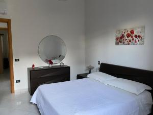 una camera con letto bianco e specchio di Villa Mare Giuggiola ad Alcamo Marina