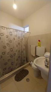 y baño con aseo y cortina de ducha. en Cozy Home with Stunning Views!, en Ponta do Sol