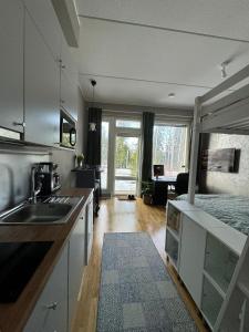 a kitchen with a sink and a living room at Modern apartment near Helsinki airport in Vantaa