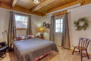 a bedroom with a bed and a chair and a window at Cozy Black Hills Retreat in Lead