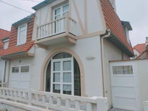 ein Haus mit einem Balkon und einem weißen Zaun in der Unterkunft Villa 300m de la plage in Le Touquet-Paris-Plage