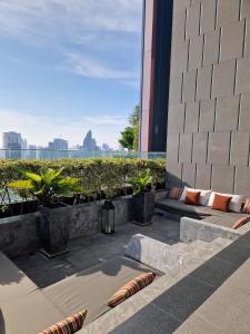 a rooftop patio with benches and plants on a building at Super Luxury Designer Sleeps 6 People in Thonglor in Bangkok
