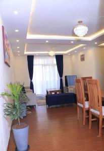 ein Wohnzimmer mit einem blauen Sofa und Stühlen in der Unterkunft Very secure apartment Bole Addis Enyi Real Estate in Addis Abeba