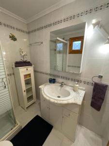 a white bathroom with a sink and a mirror at Apartament La Mata in Torrevieja