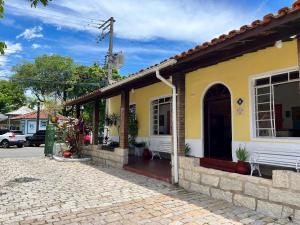 a yellow and white house with a cobblestone street at Hotel Roma in São Sebastião