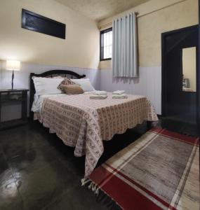 a bedroom with a bed with a table and a window at Apartamento no bairro Quitandinha - Petrópolis RJ in Petrópolis