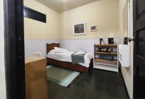 a small bedroom with a bed and a shelf at Apartamento no bairro Quitandinha - Petrópolis RJ in Petrópolis