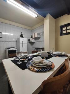 uma cozinha com uma mesa com pratos e copos de vinho em Apartamento no bairro Quitandinha - Petrópolis RJ em Petrópolis