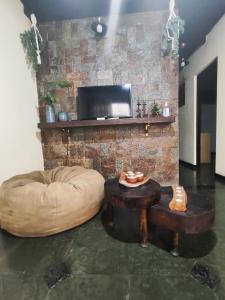 uma sala de estar com um pufe e uma mesa em Apartamento no bairro Quitandinha - Petrópolis RJ em Petrópolis