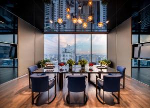 a dining room with a table and chairs and a large window at Super Luxury Designer Sleeps 6 People in Thonglor in Bangkok