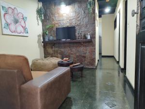 a living room with a couch and a tv on a brick wall at Apartamento no bairro Quitandinha - Petrópolis RJ in Petrópolis