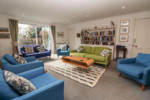 a living room with blue chairs and a green couch at Eldoret in Aldeburgh