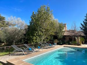 a swimming pool with chairs next to a house at Villa Estel - La Goleta Hotel de Mar & Villas in Pollença