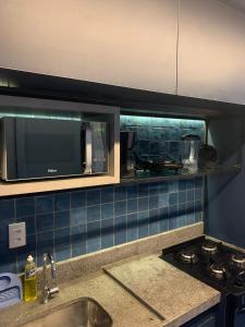 a kitchen with a sink and a microwave at Eco Resort - Praia dos Carneiros - ao lado da Igrejinha in Rio Formoso