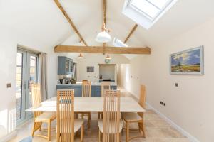 a kitchen and dining room with a table and chairs at Snipe Meadow Barn in Swafield