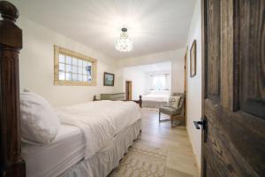 a bedroom with a large white bed and a chair at Lakefront Luxury Cottage - Shining Star - Close to Sauble Beach in Wiarton