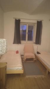 Cette chambre comprend 2 lits et une fenêtre. dans l'établissement Apartmán Malá Turná, à Strakonice