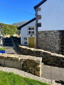 a stone retaining wall in front of a house at Little Hillside in Porthtowan