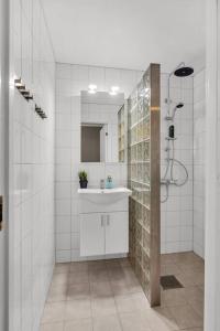 a white bathroom with a sink and a shower at Flott og sentral moderne leilighet på 2 etasjer in Tromsø