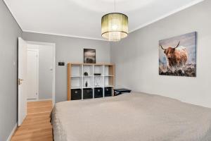 a bedroom with a bed and a picture of a bull at Flott og sentral moderne leilighet på 2 etasjer in Tromsø