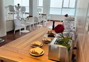 un tavolo con panini e un vaso con un fiore sopra di Roomie Salta by DOT Suites a Salta