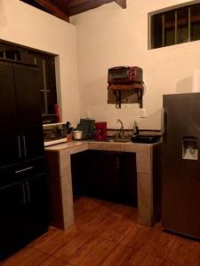 uma cozinha com um lavatório e um balcão com uma mala em Cabaña Sabana Redonda, Poás em Poás