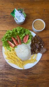 un plato de comida con arroz y carne y patatas fritas en Itaverá Master Hotel, en Presidente Prudente