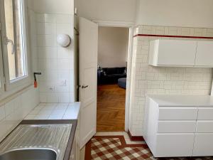 a small kitchen with a sink and a window at GRAND APPARTEMENT de 120 m2 à 5 minutes du Metro 7 lits in Les Lilas +25 photos