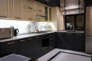 a kitchen with black cabinets and white appliances at Learmara Apartment #2 in Samarkand