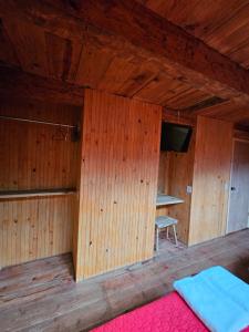 Cette chambre dispose de murs en bois, d'une table et d'un lit. dans l'établissement cabañas en zacatlan, à Zacatlán