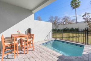 un patio con mesa y sillas junto a una piscina en SUPER CLOSE - DISNEY's PARKs with THEME ROOMs & POOL, en Orlando