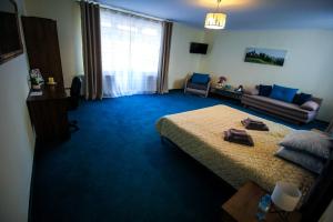 a bedroom with a bed and a living room with a couch at Zara Apartament 1 in Târgu-Mureş