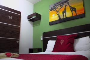 a bedroom with a bed and a painting of giraffes at Hotel NK in Santiago Pinotepa Nacional