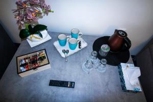 a table with cups and wine glasses on it at Zara Apartament 1 in Târgu-Mureş