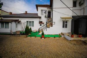 a house with a green lawn in front of it at Zara Apartament 1 in Târgu-Mureş