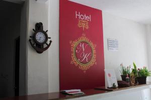 a clock on a wall next to a hotel sign at Hotel NK in Santiago Pinotepa Nacional