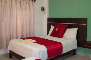 a bedroom with a large bed with a red blanket at Hotel NK in Santiago Pinotepa Nacional