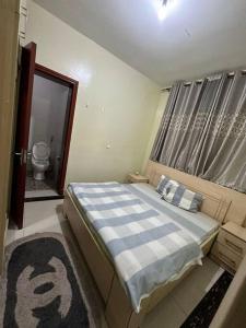 een slaapkamer met een bed en een badkamer met een toilet bij Private house in Kibagabaga in Kigali