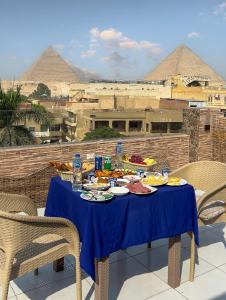 una tavola con cibo sopra con piramidi sullo sfondo di Makadi Pyramids View a Il Cairo Altre 37 foto